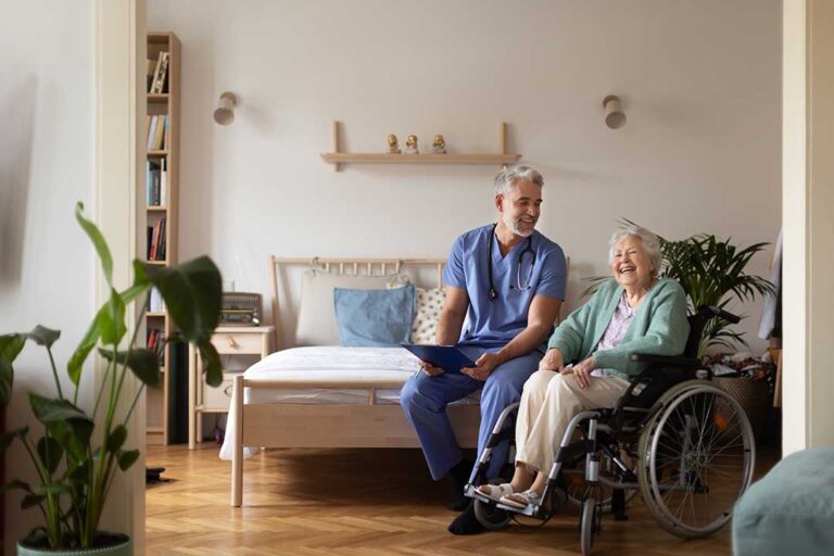 Older adult using a walker on a clear hallway beside a handrail and bright nighttime lighting.